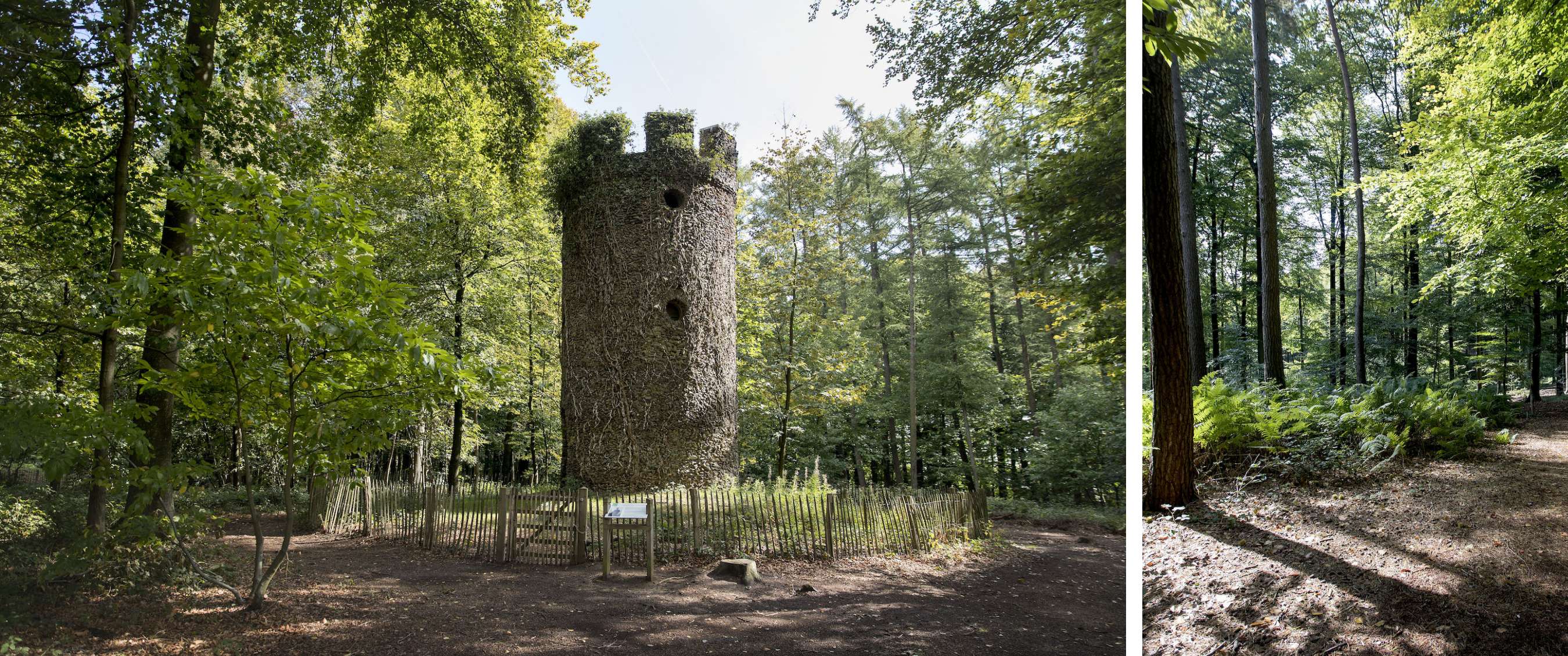 Ronde houten toren met kleine openingen staat achter een lage omheining tussen groene bomen.