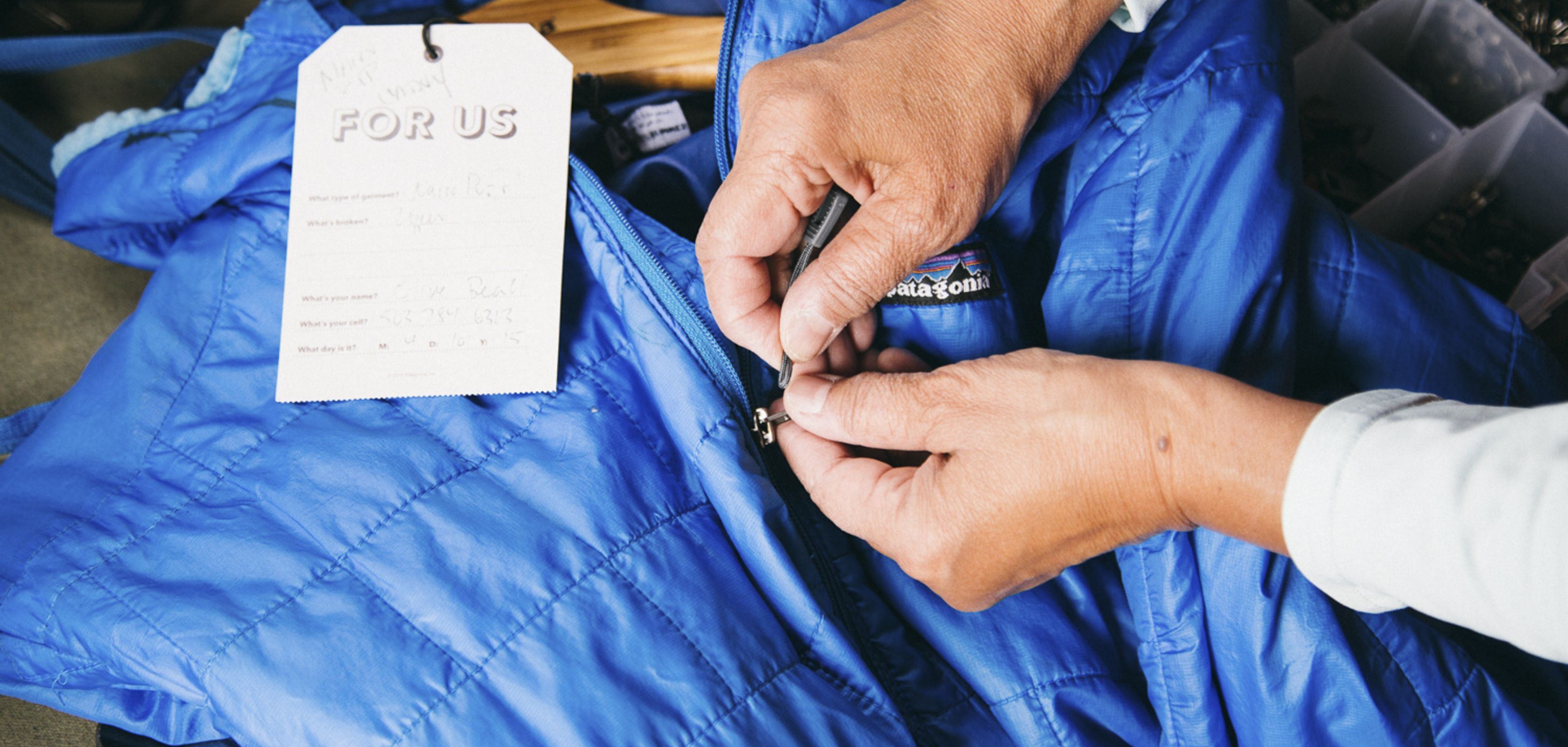 Une femme répare un vêtement dans le United Repair Centre de Patagonia