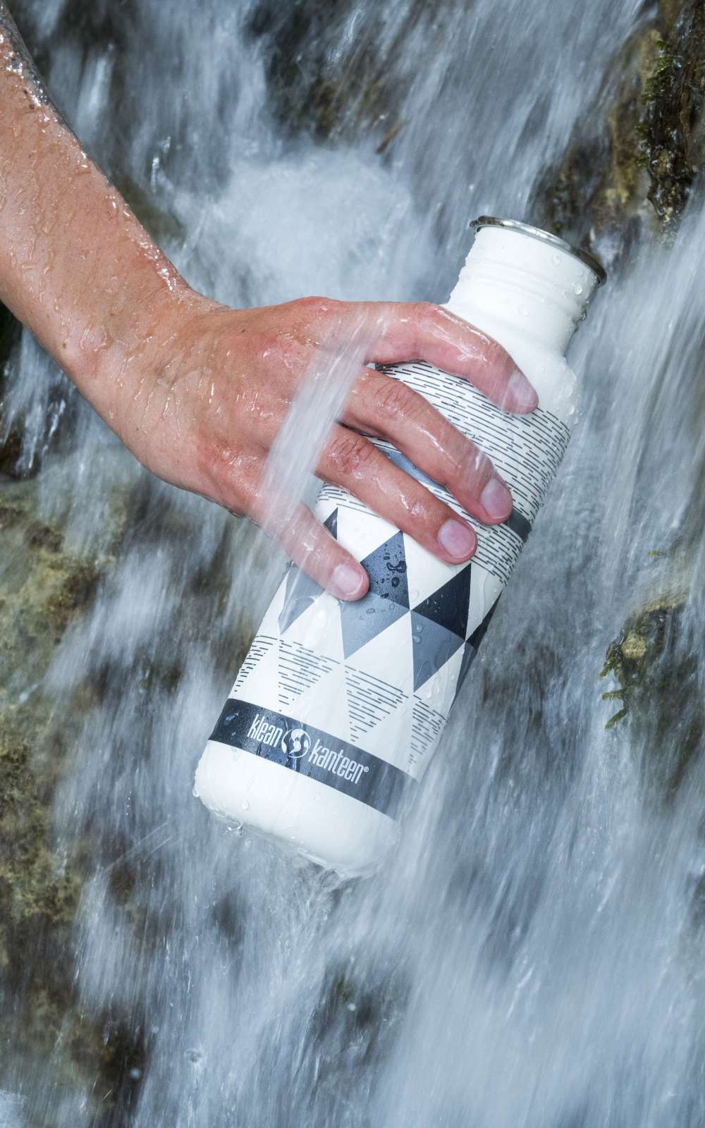 Witte drinkfles met Klean Kanteen-logo wordt vastgehouden in een waterstroom.