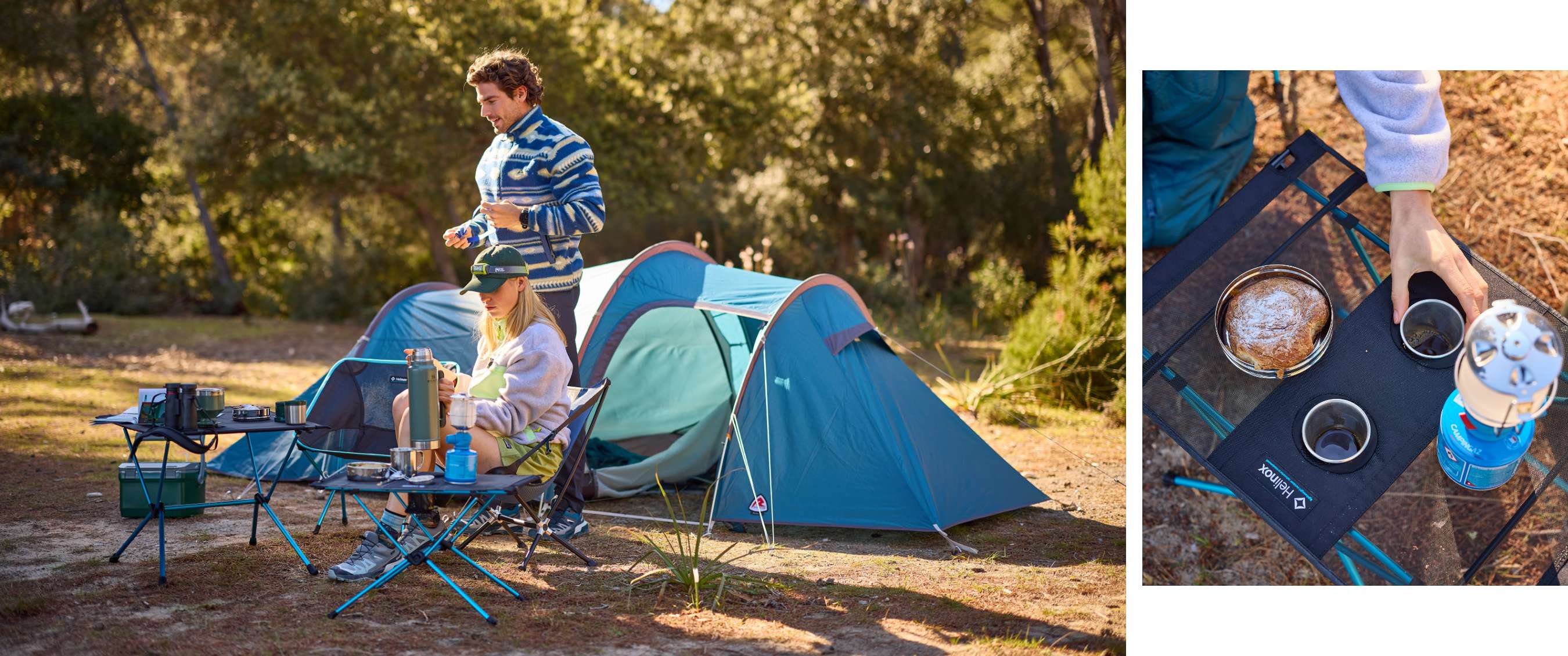 Emplacement de camping avec deux personnes, tentes bleues, chaises, tables et matériel de cuisine entre les arbres.